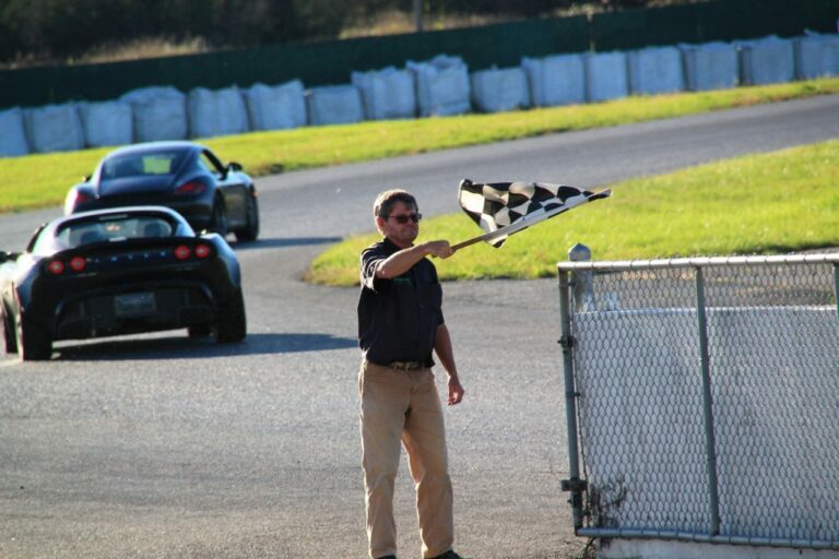 A person waving a checkered flag on a race car track
