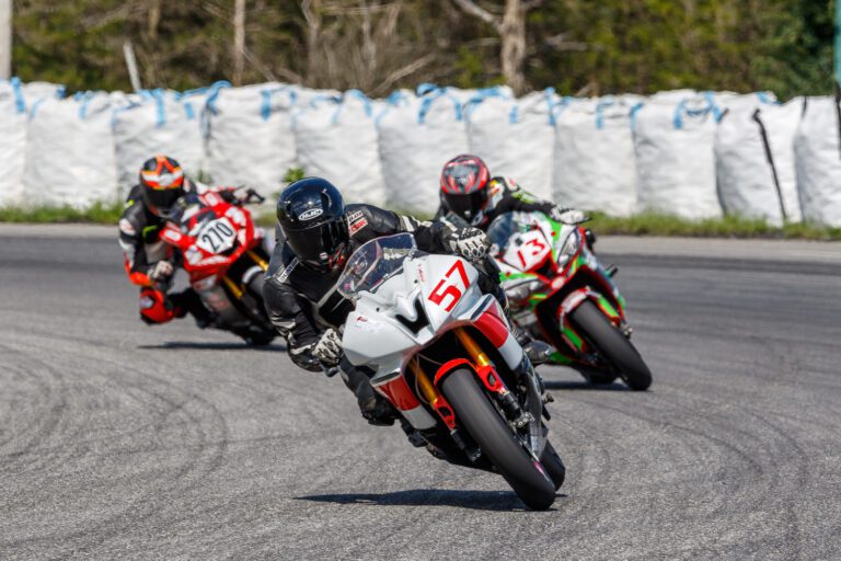Three racing motorcycles turning a corner on a race track