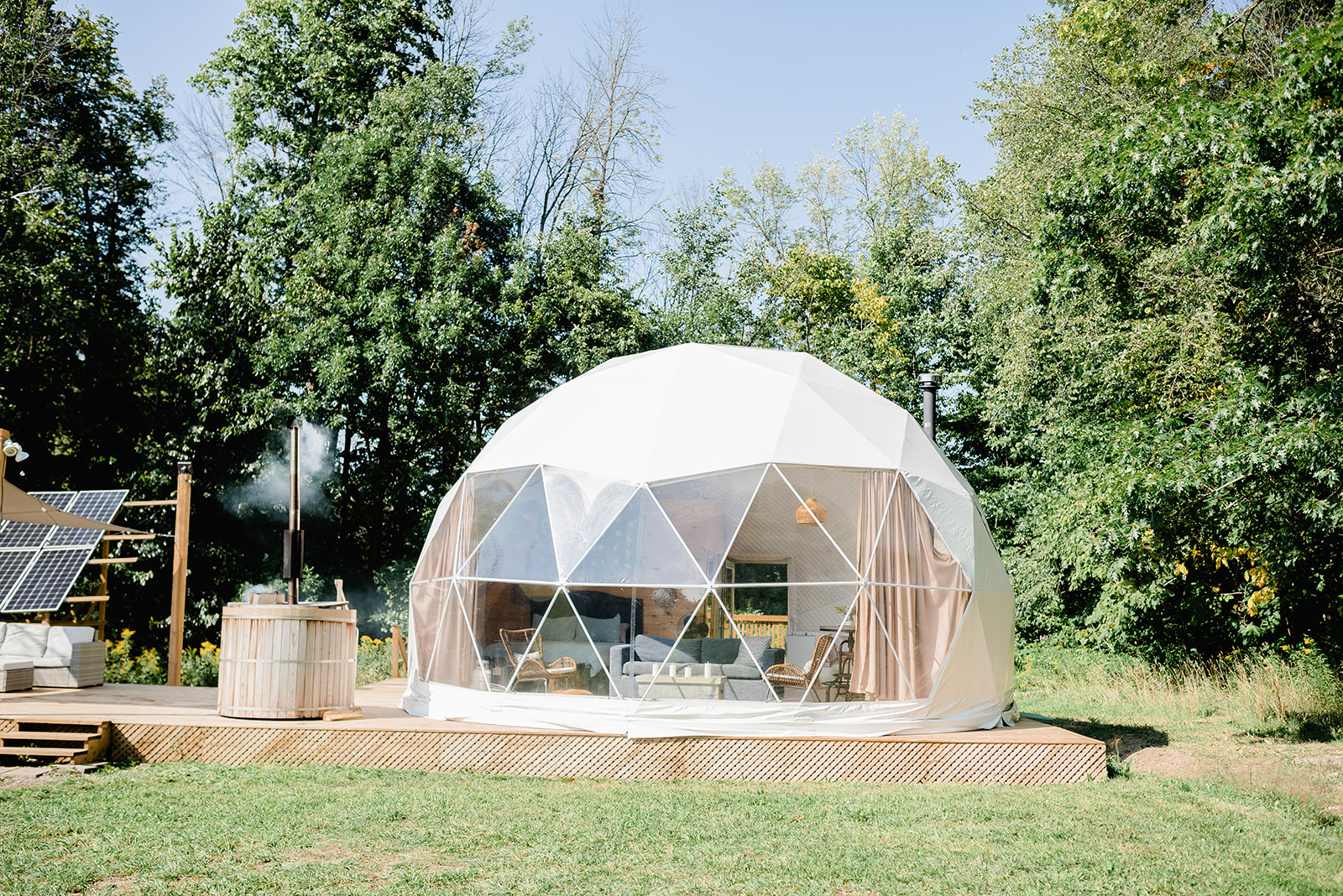 a glamping dome with trees in the background