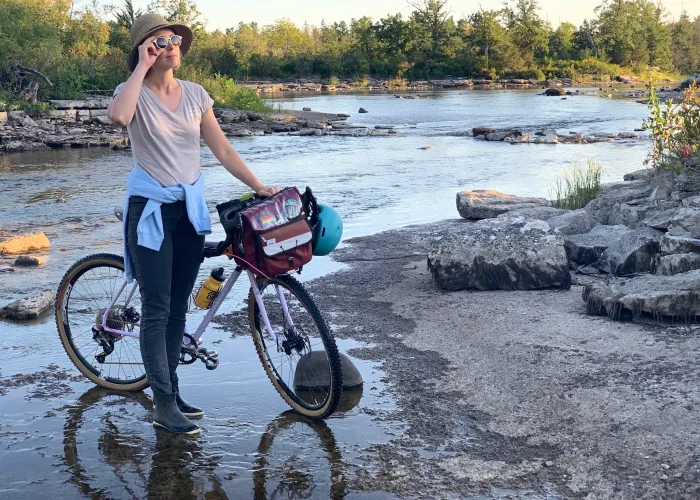 Woman and her bike at Callaghan Rapids Conservation Area at sunset in Marmora, Ontario