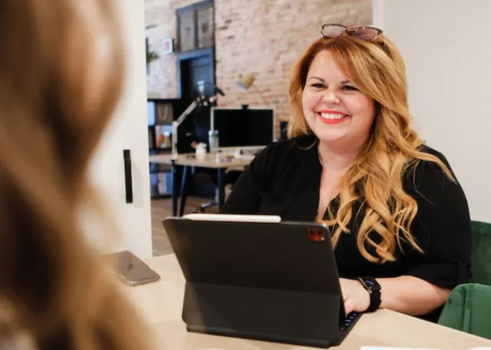 Karine Parthenais sitting at a table typing on a laptop