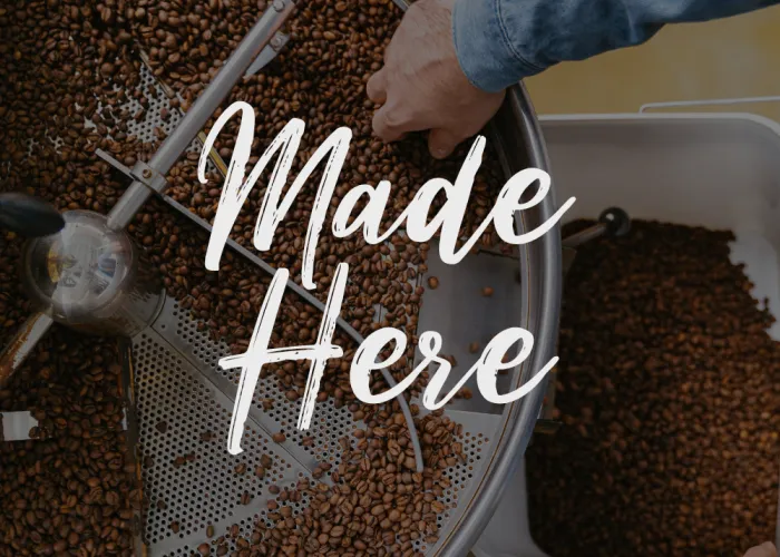 Made Here Title Photo, a person is roasting coffee in a large metal machine