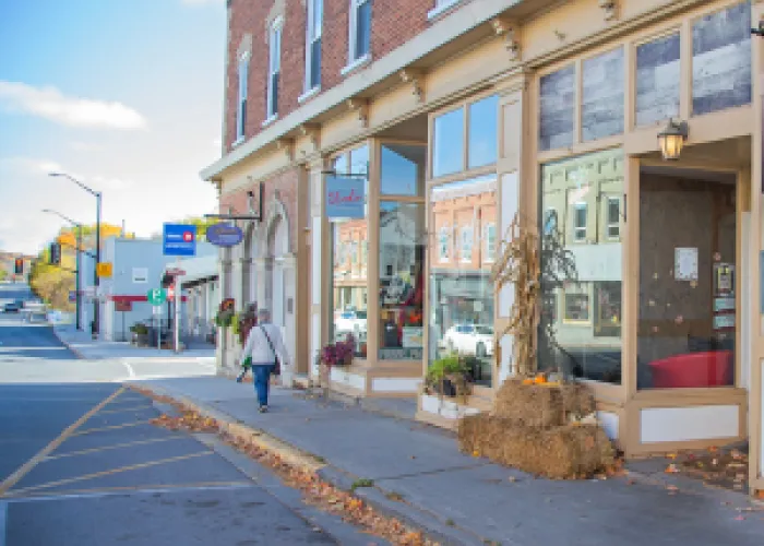 A picture of a townscape with a person walking on the side walk in the distance. 